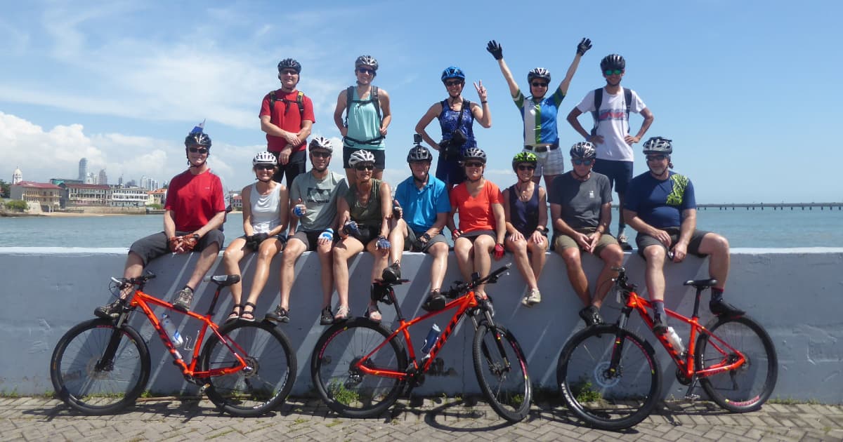 group of cyclists standing on a wall after finishing a bike trail