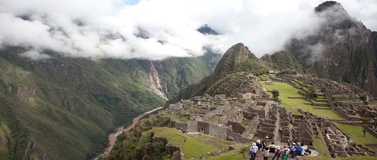 a group of tourists exploring the ruins of Machu Picchu