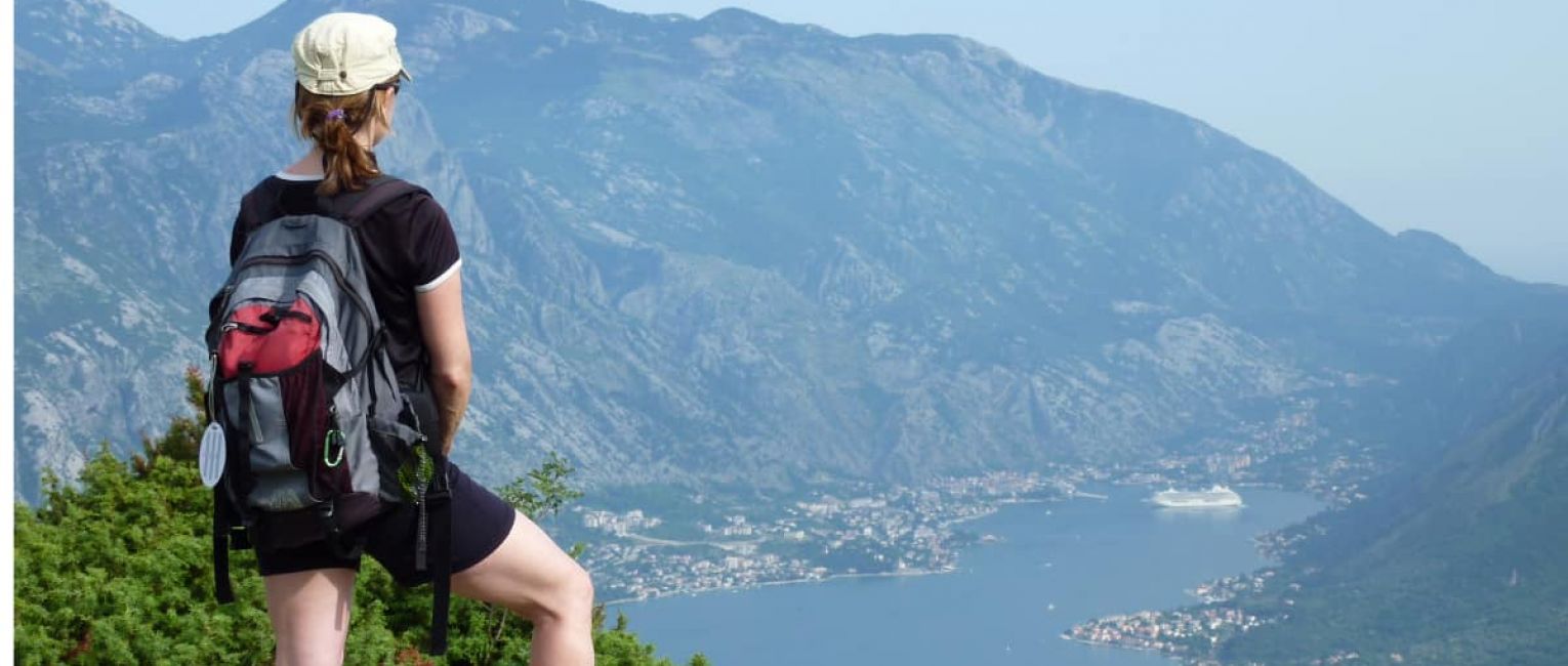 Solo traveler standing on mountain overlooking lake